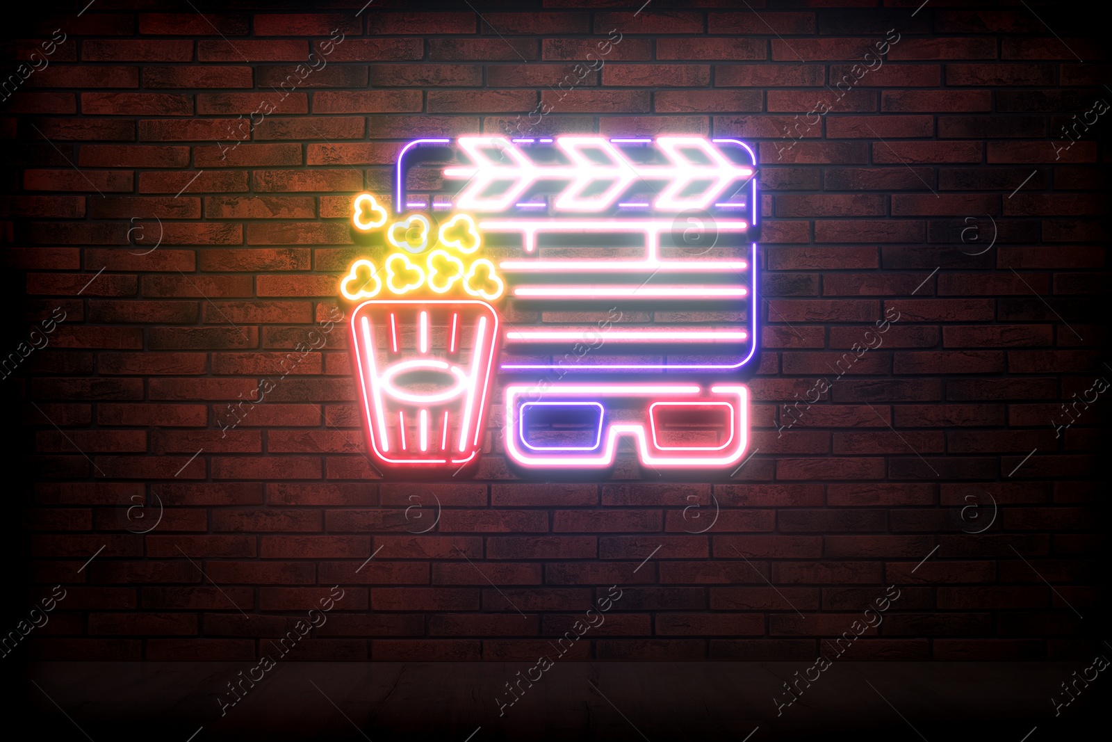 Image of Glowing neon sign with popcorn bucket, clapper and glasses on brick wall