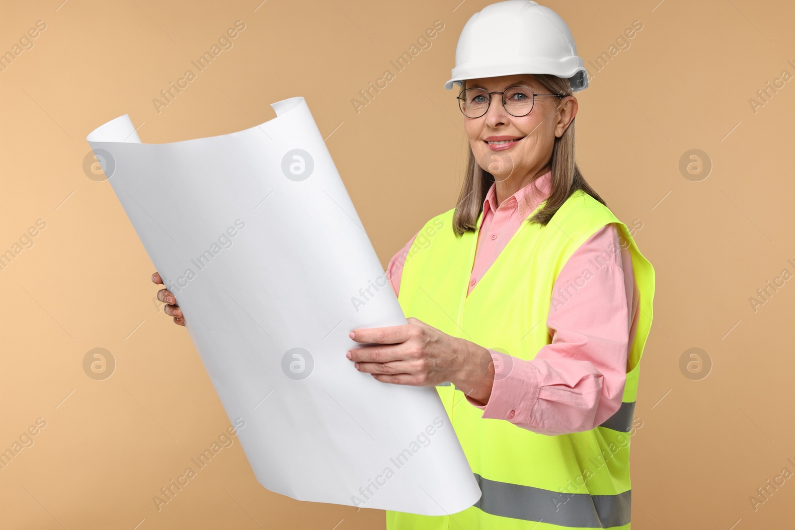 Photo of Architect in hard hat with draft on beige background