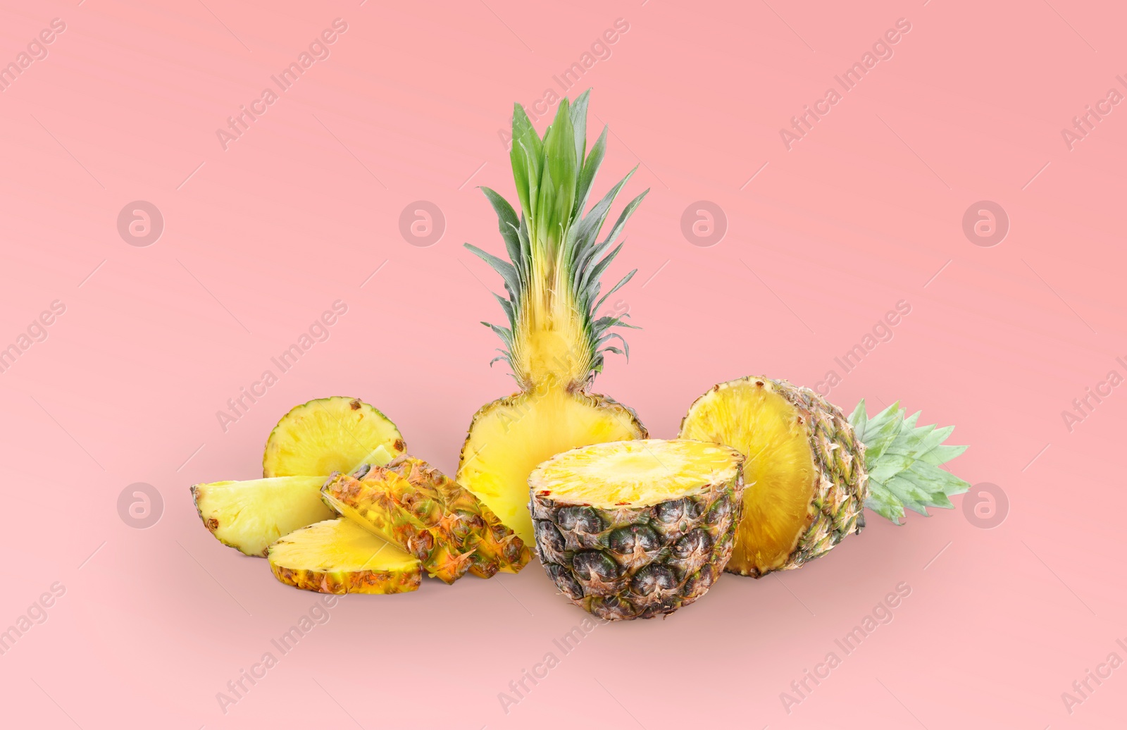 Image of Cut fresh juicy pineapples on light red background