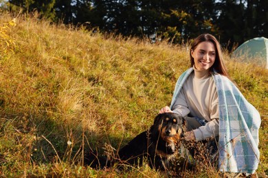 Photo of Woman petting cute dog on grassy hill