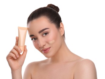 Photo of Woman holding tube of foundation on white background