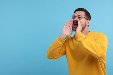 Photo of Special promotion. Man shouting to announce information on light blue background. Space for text