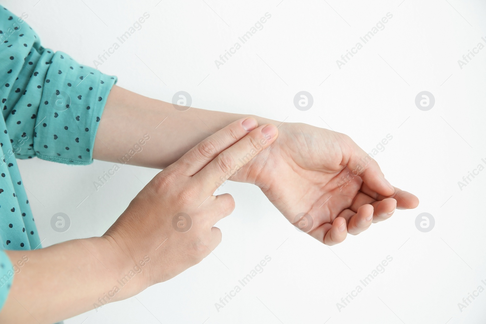 Photo of Young woman checking pulse on light background