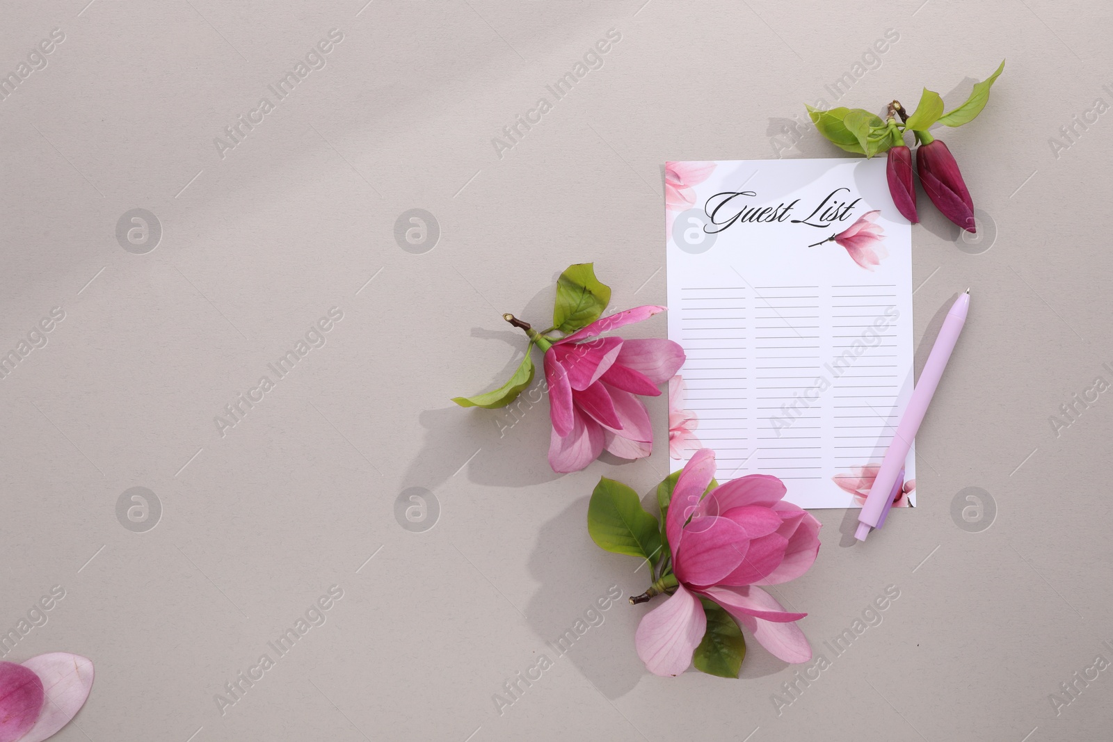 Photo of Guest list, pen and beautiful flowers on grey background, flat lay. Space for text