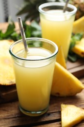 Delicious pineapple juice and fresh fruit on wooden table