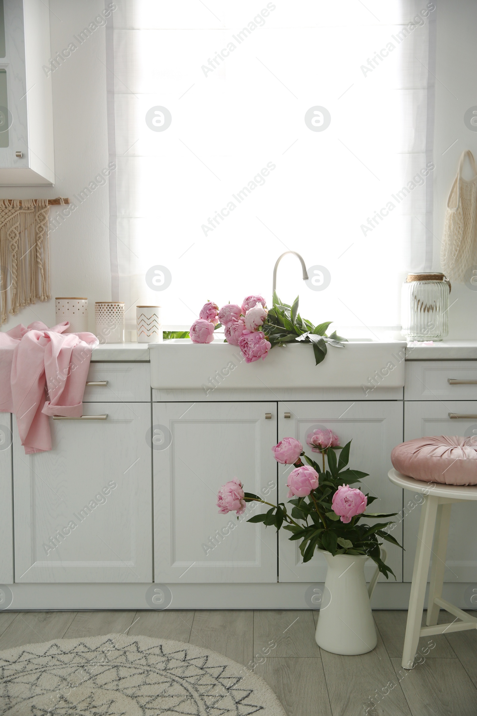 Photo of Beautiful pink peonies in stylish kitchen interior