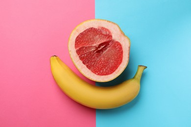 Photo of Banana and half of grapefruit on color background, flat lay. Sex concept