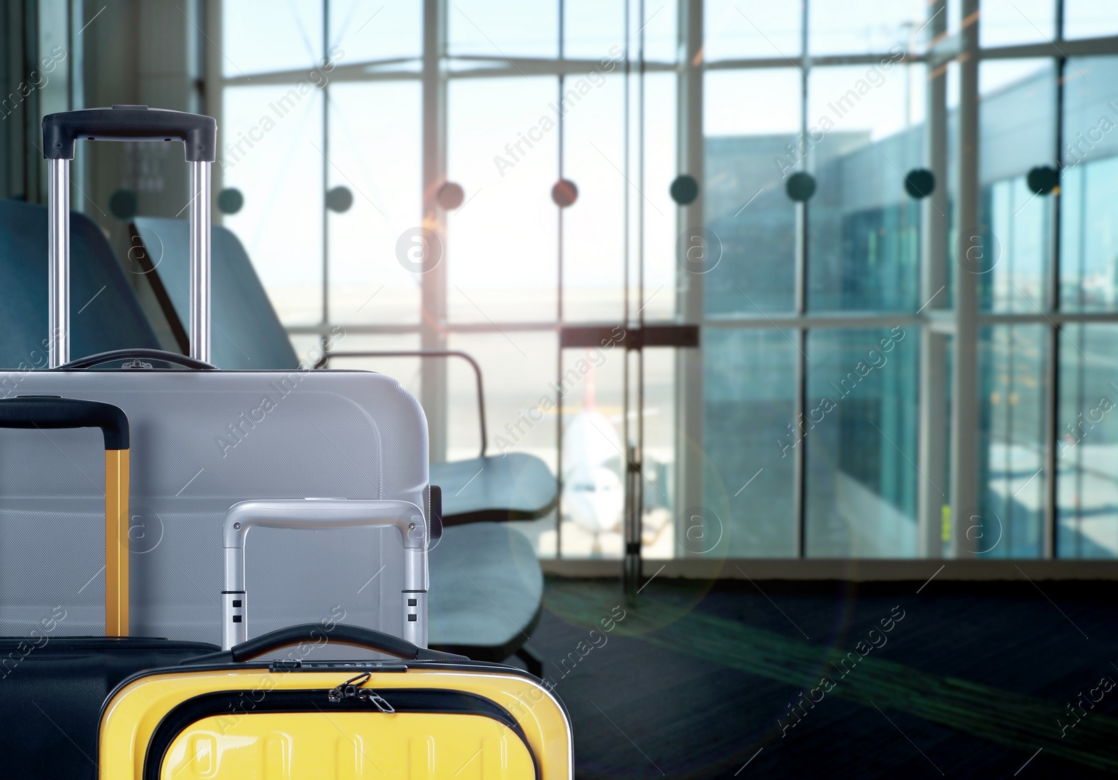 Image of Stylish suitcases in waiting area at airport terminal