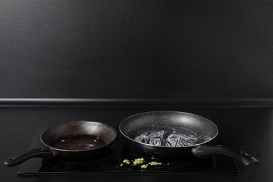 Photo of Dirty frying pans on cooktop in kitchen