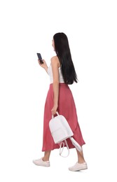 Photo of Young woman using smartphone while walking on white background