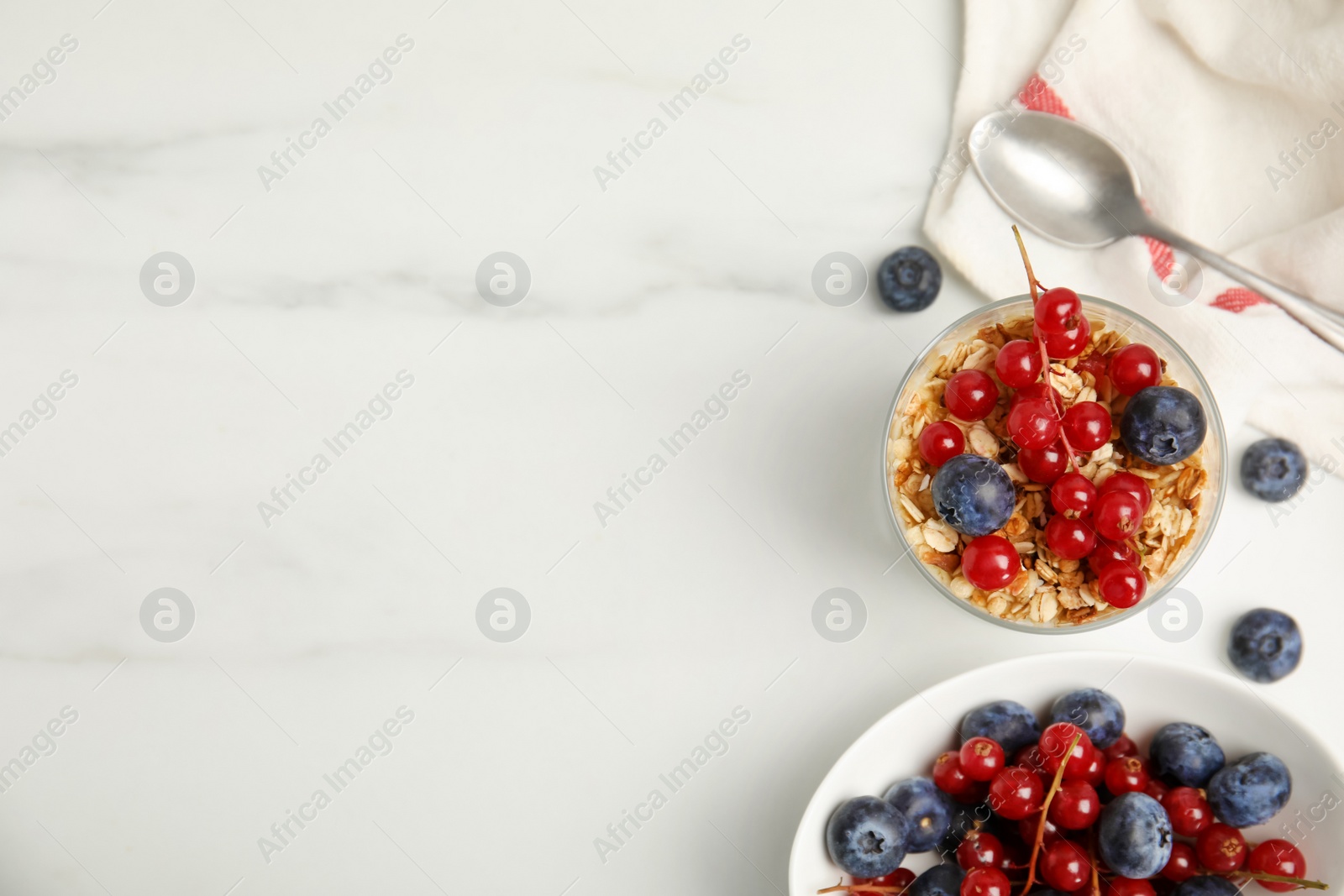 Photo of Delicious yogurt parfait with fresh berries on white table, flat lay. Space for text