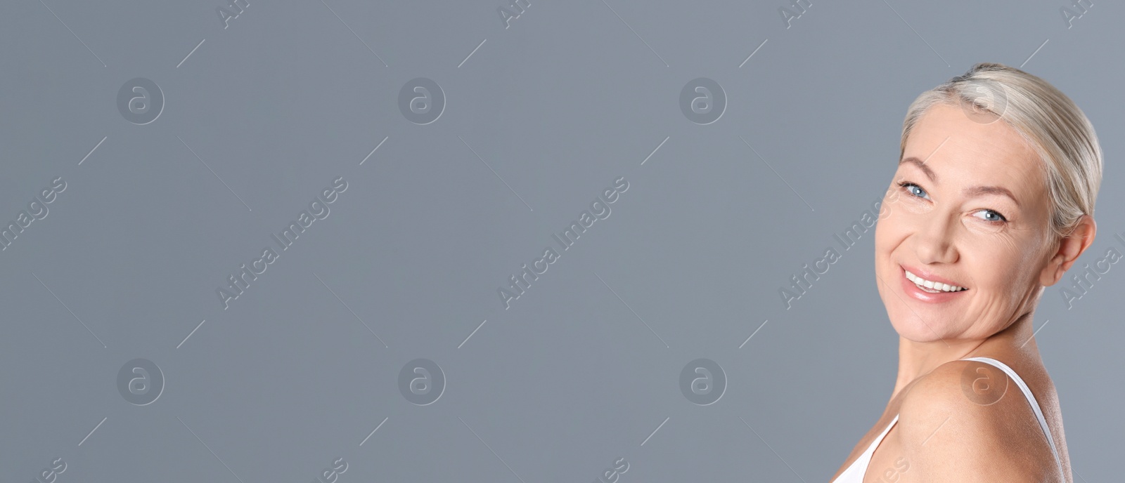 Image of Portrait of beautiful mature woman on grey background, space for text. Banner design