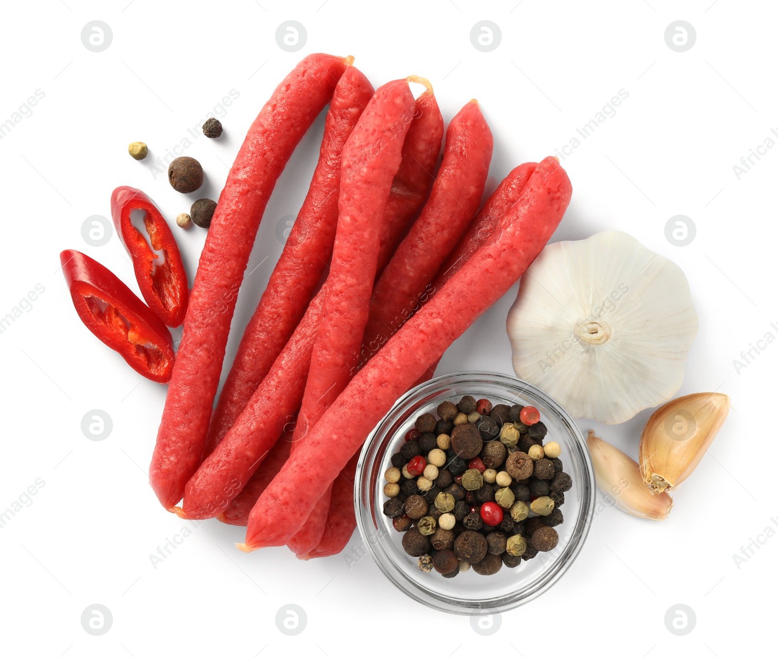 Photo of Thin dry smoked sausages and different spices isolated on white, top view