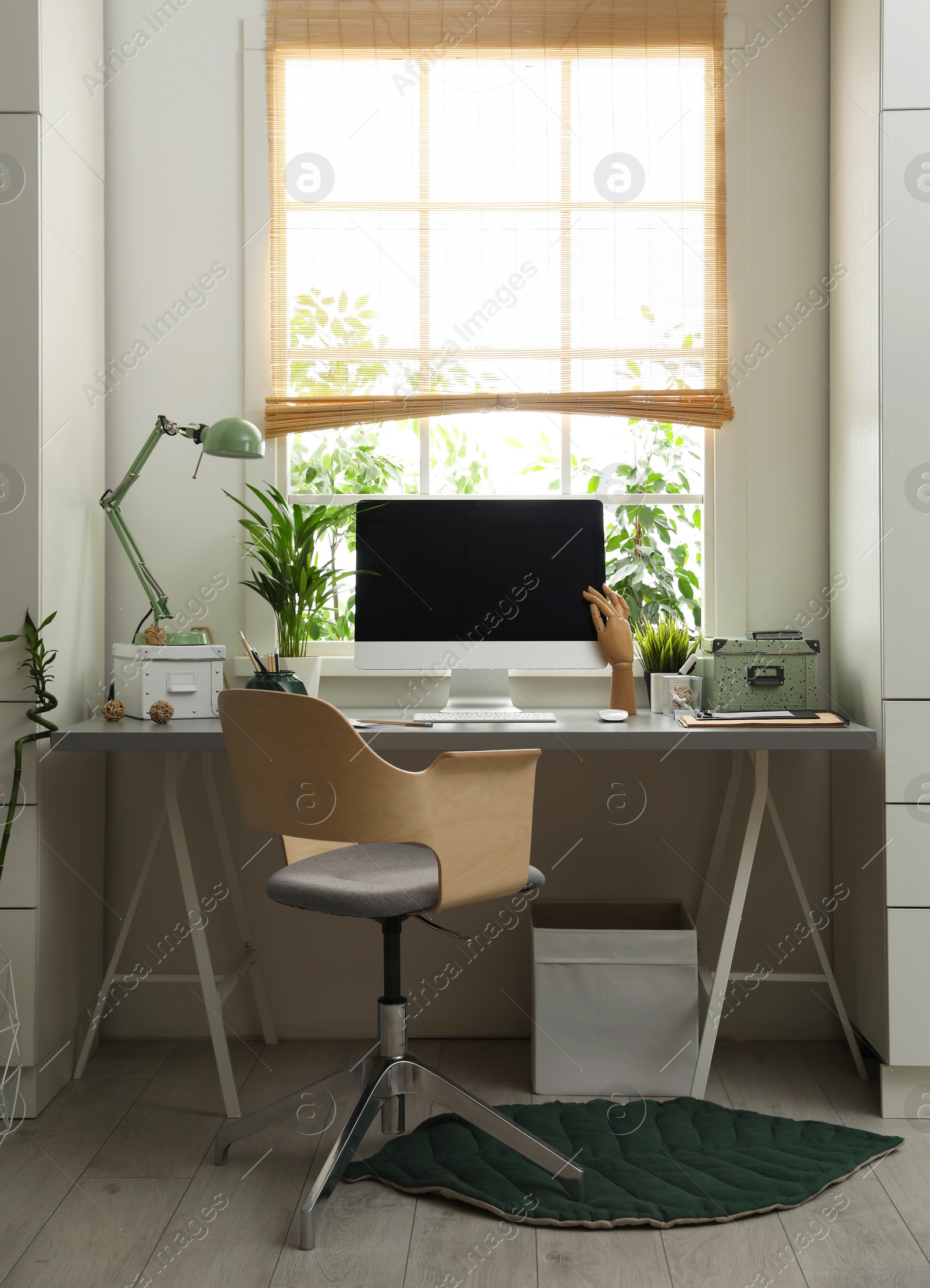 Photo of Light work place with computer near window at home. Interior design