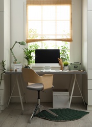 Photo of Light work place with computer near window at home. Interior design