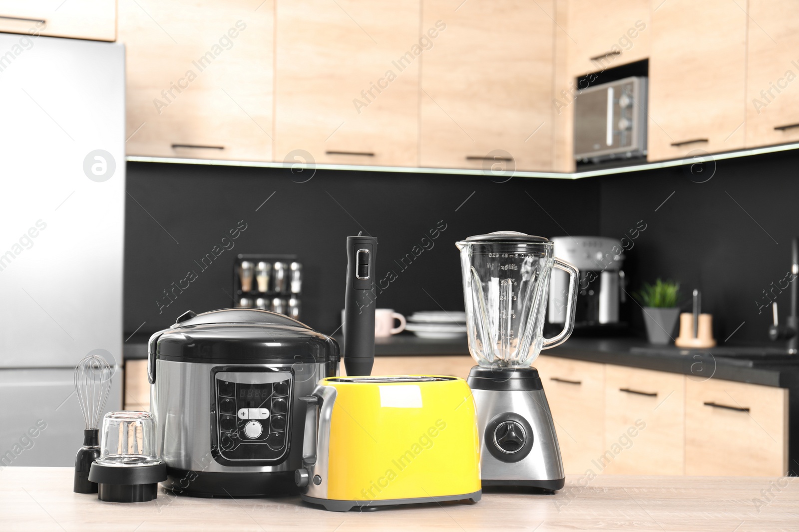 Photo of Modern domestic appliances on wooden table in kitchen. Space for text