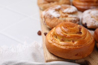 Photo of Sweet buns. Delicious rolls with raisins on table, closeup. Space for text