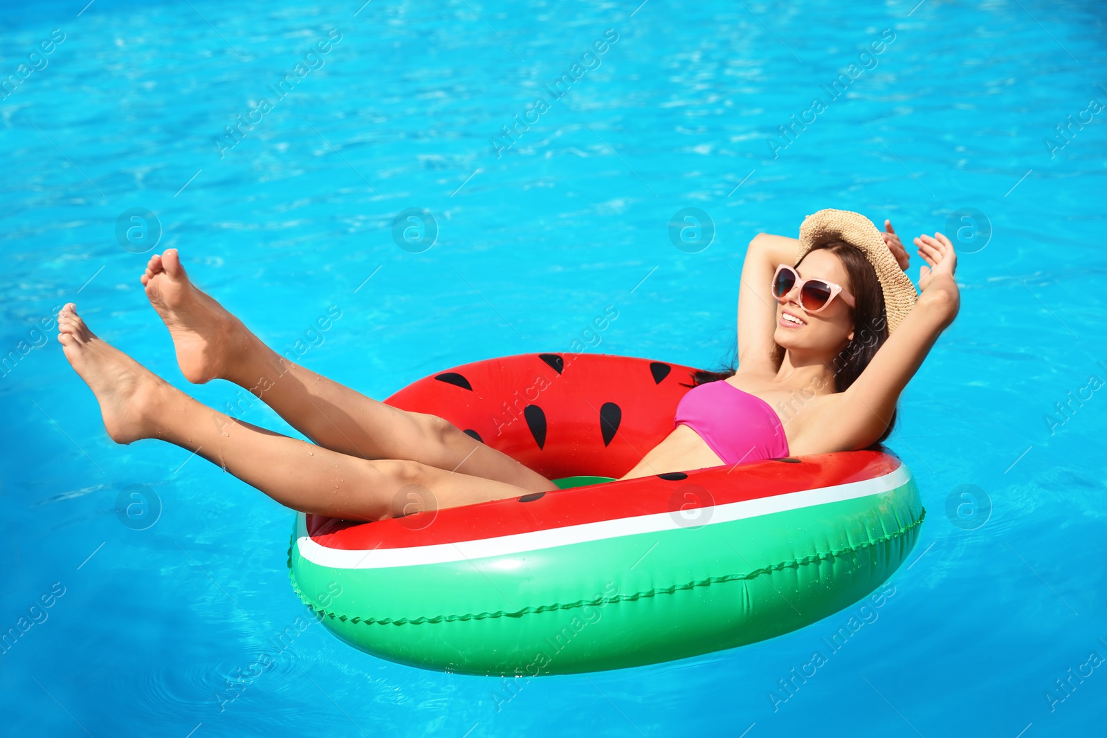 Photo of Beautiful young woman with inflatable ring in swimming pool