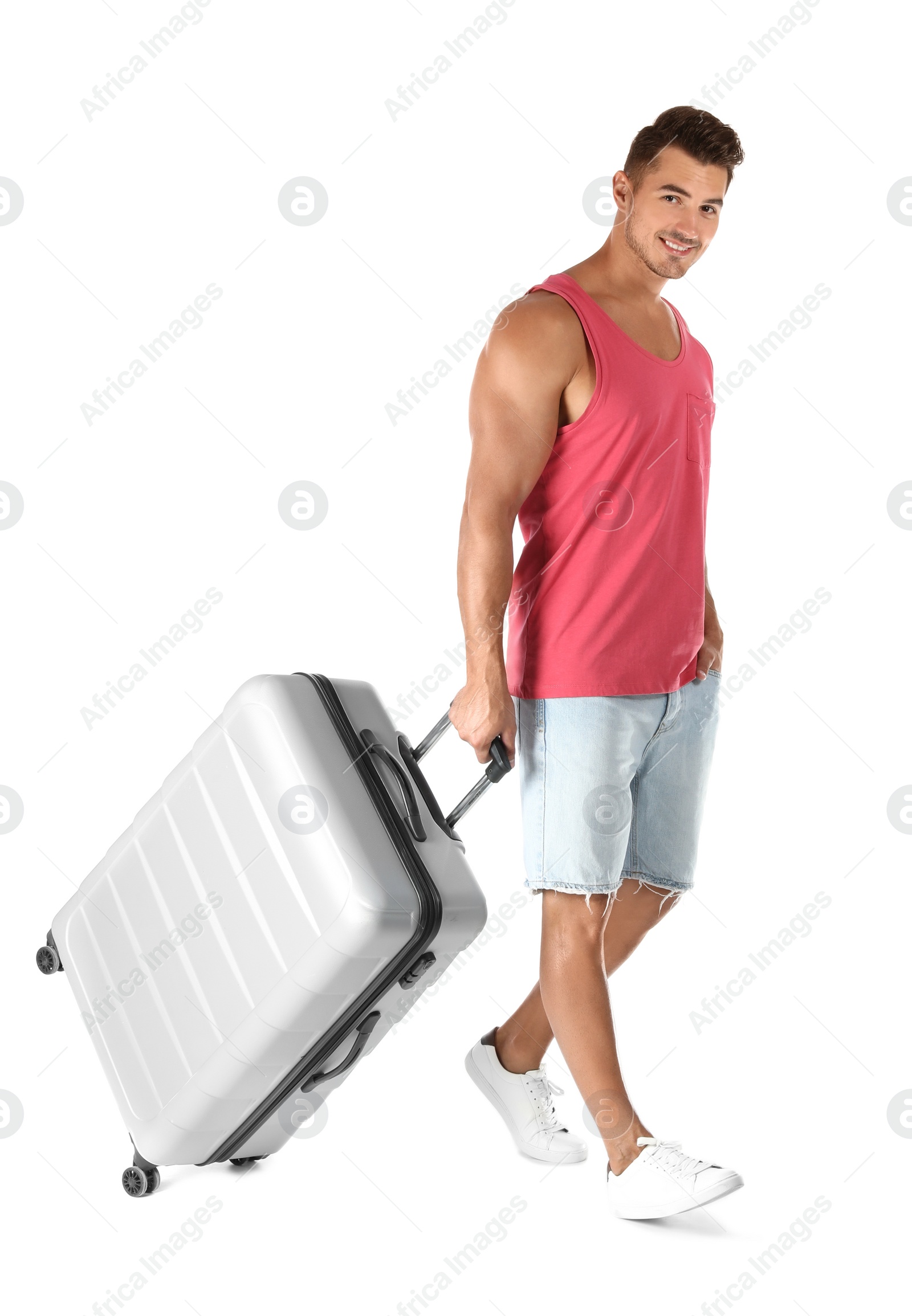 Photo of Young man walking with suitcase on white background