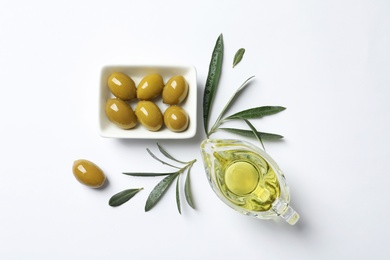 Beautiful composition with oil and ripe olives on white background