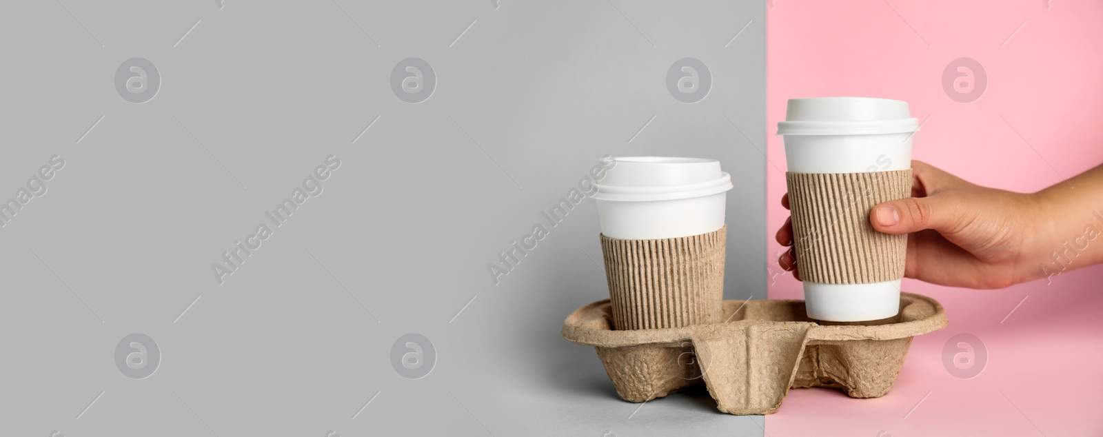 Image of Woman taking paper coffee cup from cardboard holder on color background, closeup. Banner design with space for text