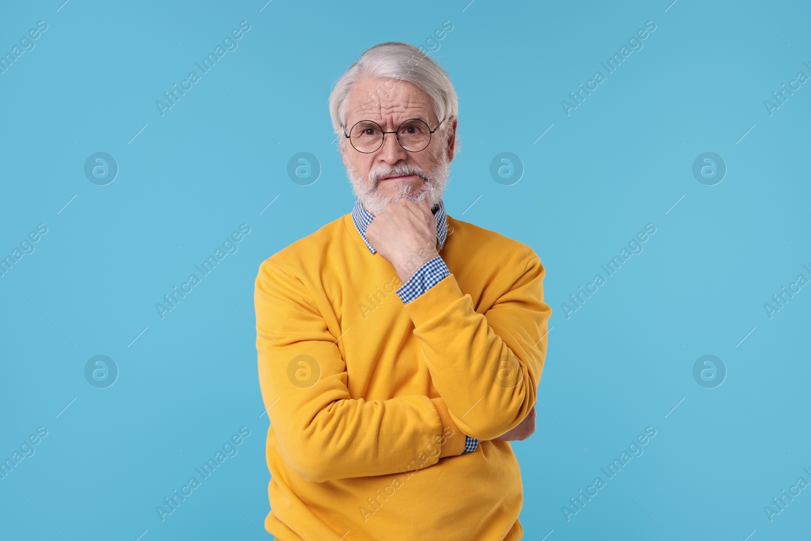 Photo of Portrait of stylish grandpa with glasses on light blue background