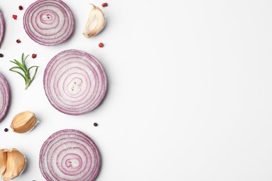 Fresh red onions, garlic, rosemary and spices on white background, flat lay. Space for text