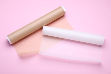 Rolls of baking paper on pink background, top view