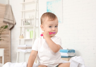 Cute little boy with toothbrush on blurred background