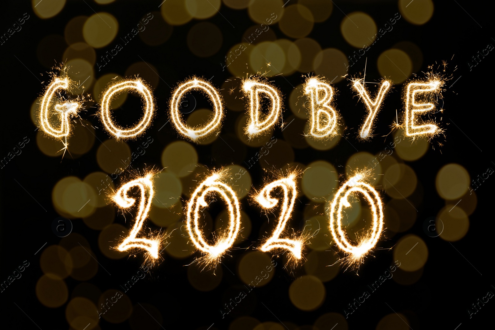 Image of  Goodbye 2020. Bright text made of sparkler on black background with blurred lights