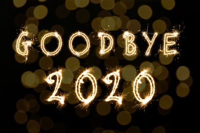 Image of  Goodbye 2020. Bright text made of sparkler on black background with blurred lights