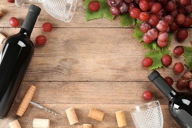 Photo of Flat lay composition with tasty red wine and grapes on wooden table, space for text