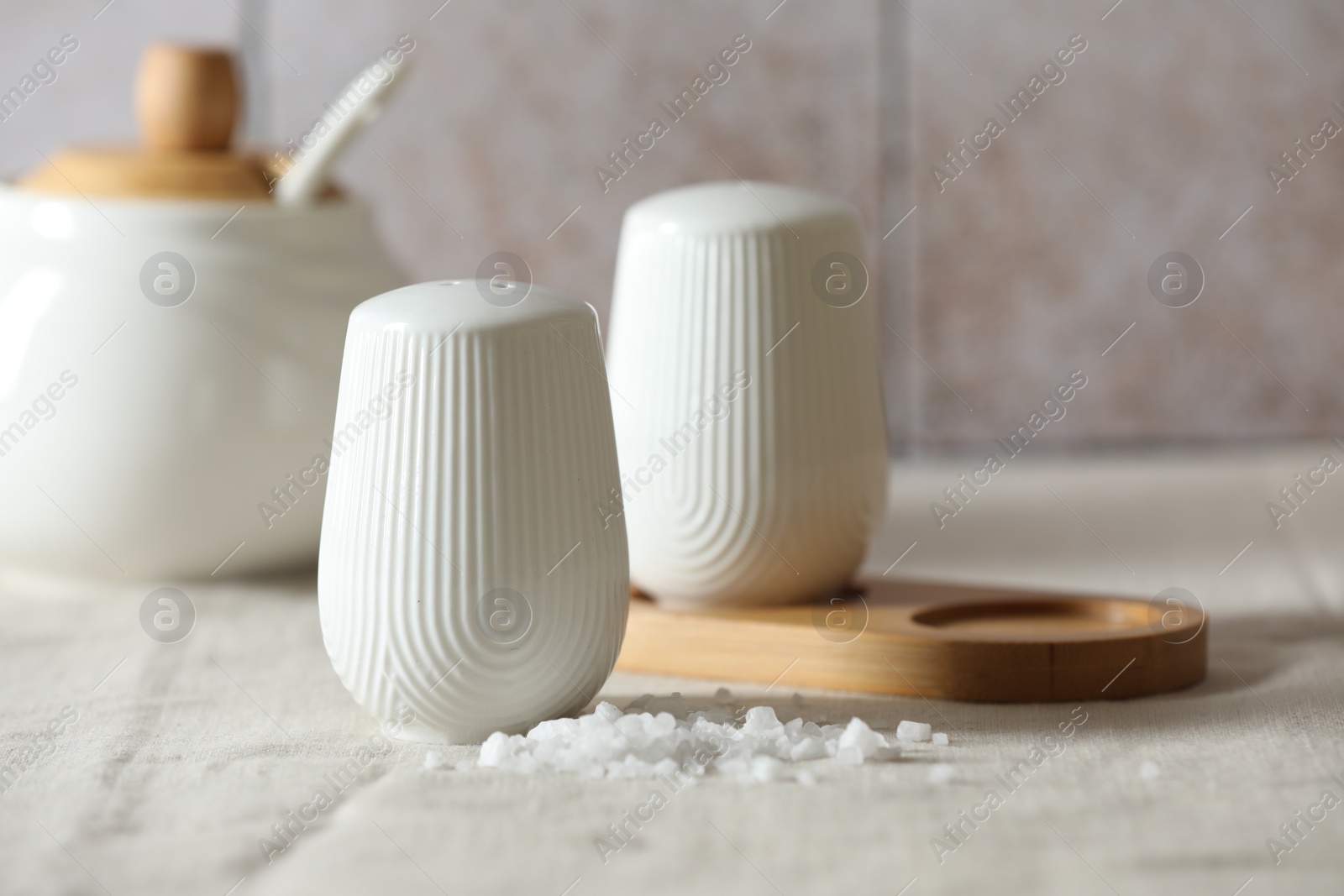 Photo of Organic salt and shaker on table, closeup. Space for text