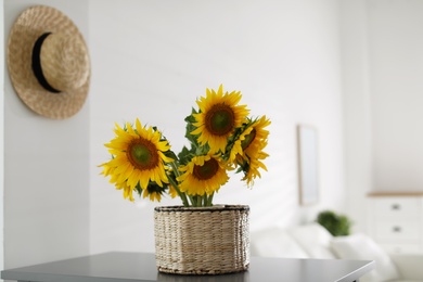 Beautiful yellow sunflowers on table in room