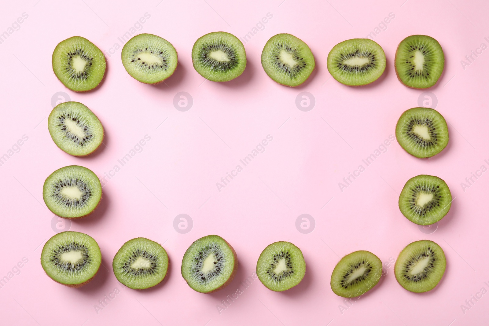 Photo of Frame made of fresh kiwis on pink background, top view. Space for text