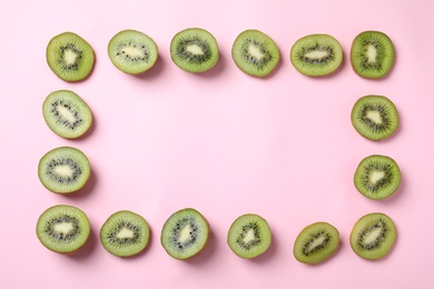 Frame made of fresh kiwis on pink background, top view. Space for text