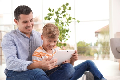 Father with child using tablet at home. Happy family