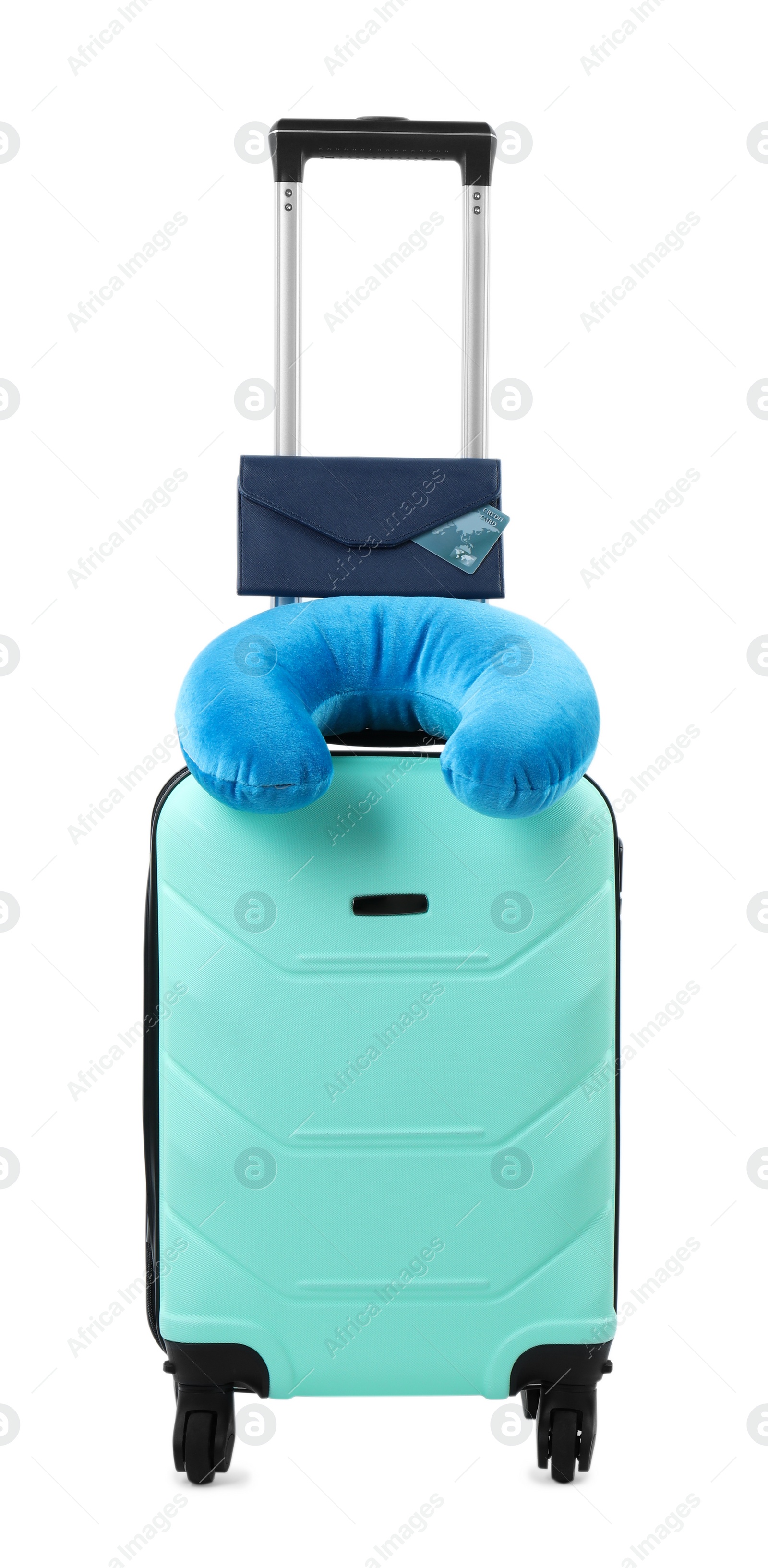 Photo of Soft travel pillow and purse on turquoise suitcase isolated on white