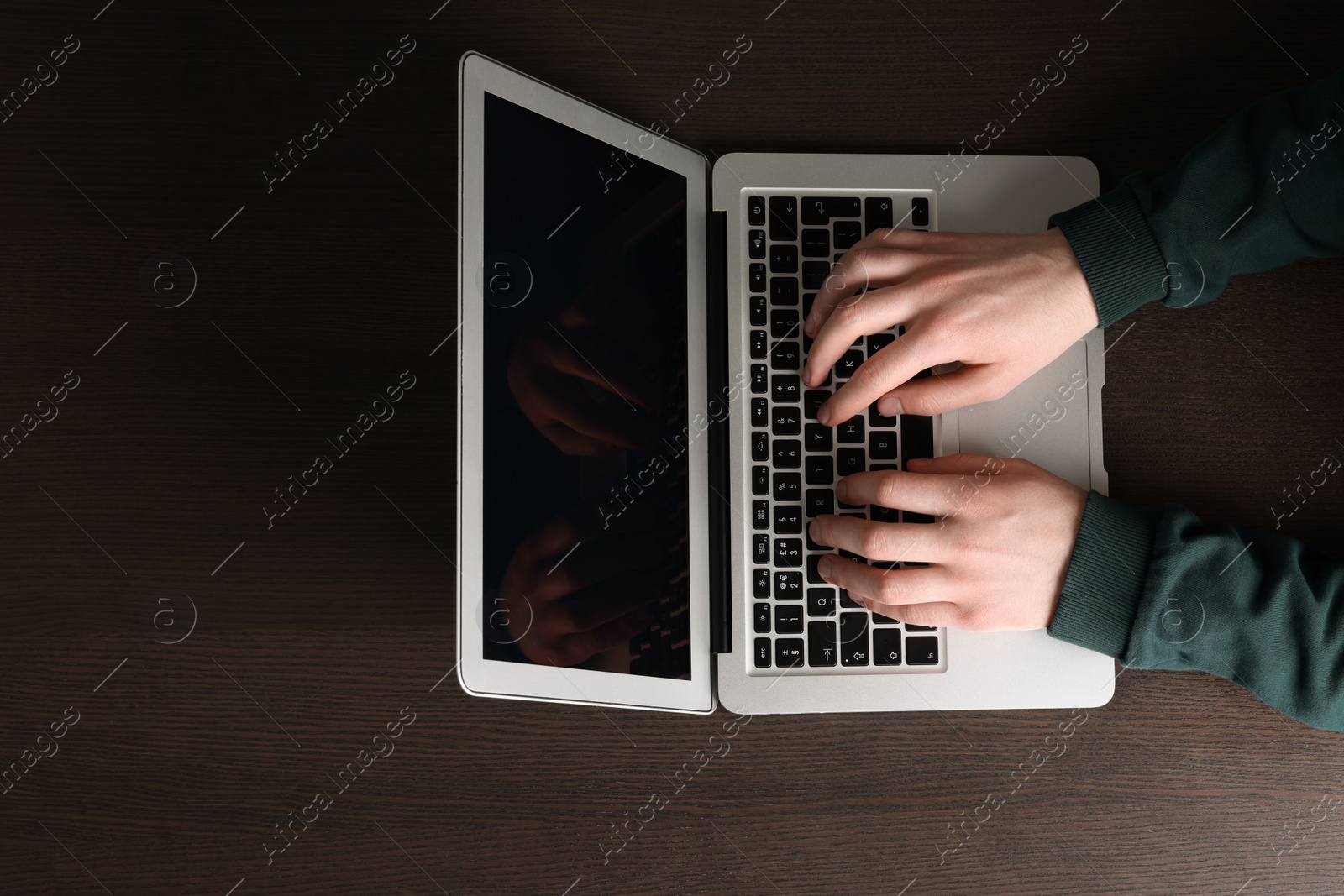 Photo of Man working with laptop at wooden table, top view. Space for text