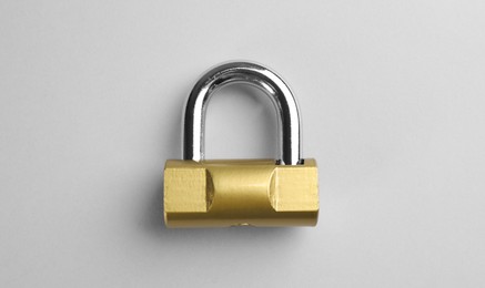 Modern padlock on light background, top view