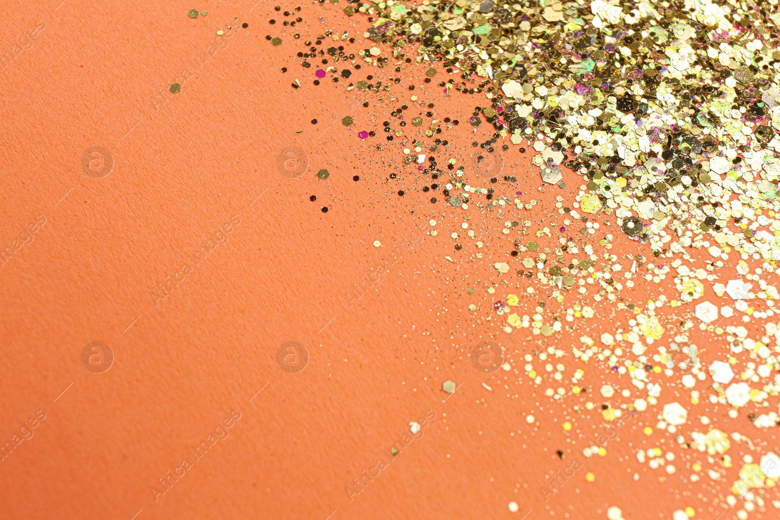 Photo of Shiny bright glitter on pale coral background. Space for text