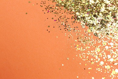 Photo of Shiny bright glitter on pale coral background. Space for text