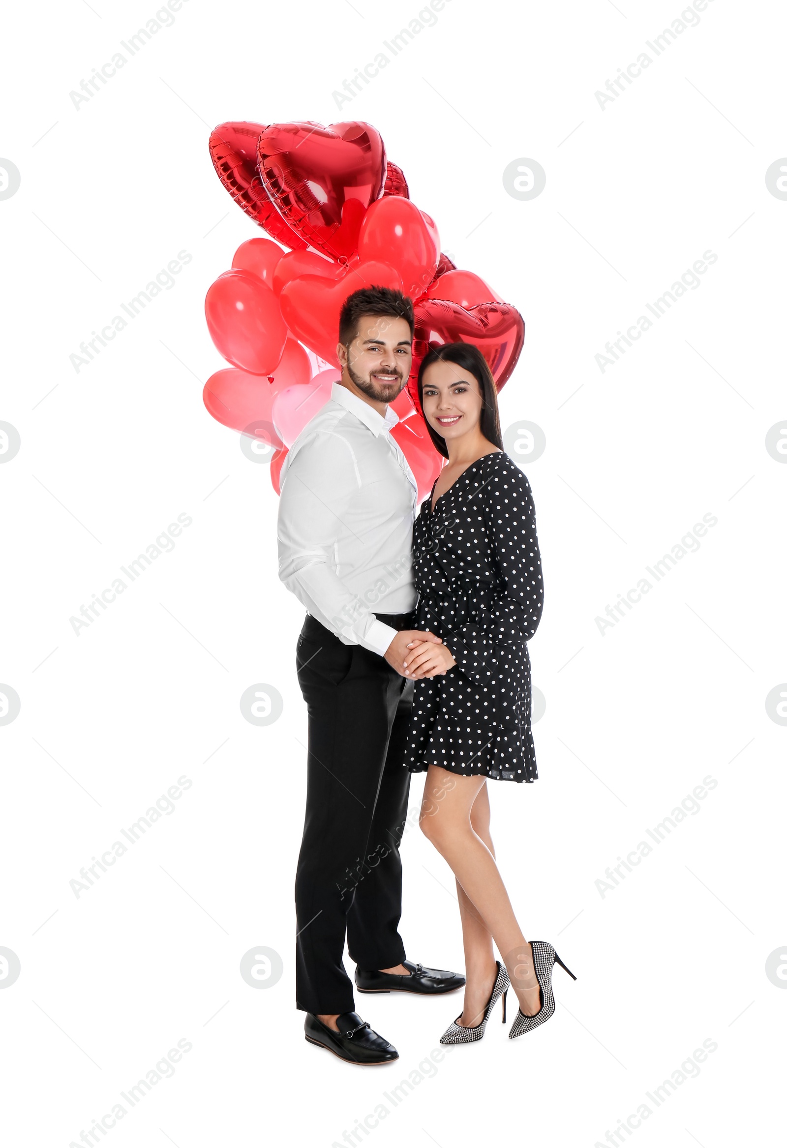 Photo of Happy young couple with heart shaped balloons isolated on white. Valentine's day celebration