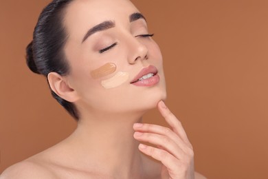 Photo of Woman with swatches of foundation on face against brown background. Space for text