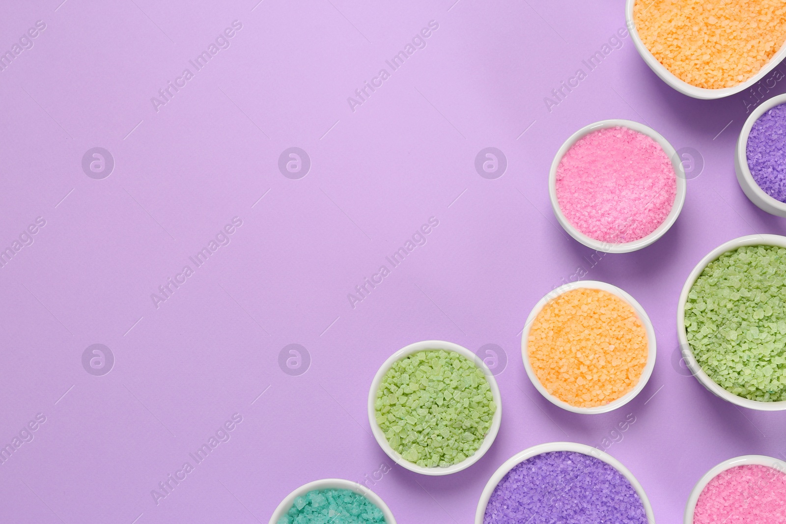 Photo of Different types of aromatic sea salt on purple background, flat lay. Space for text