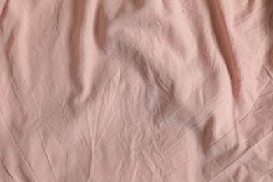 Photo of Crumpled pink fabric as background, top view