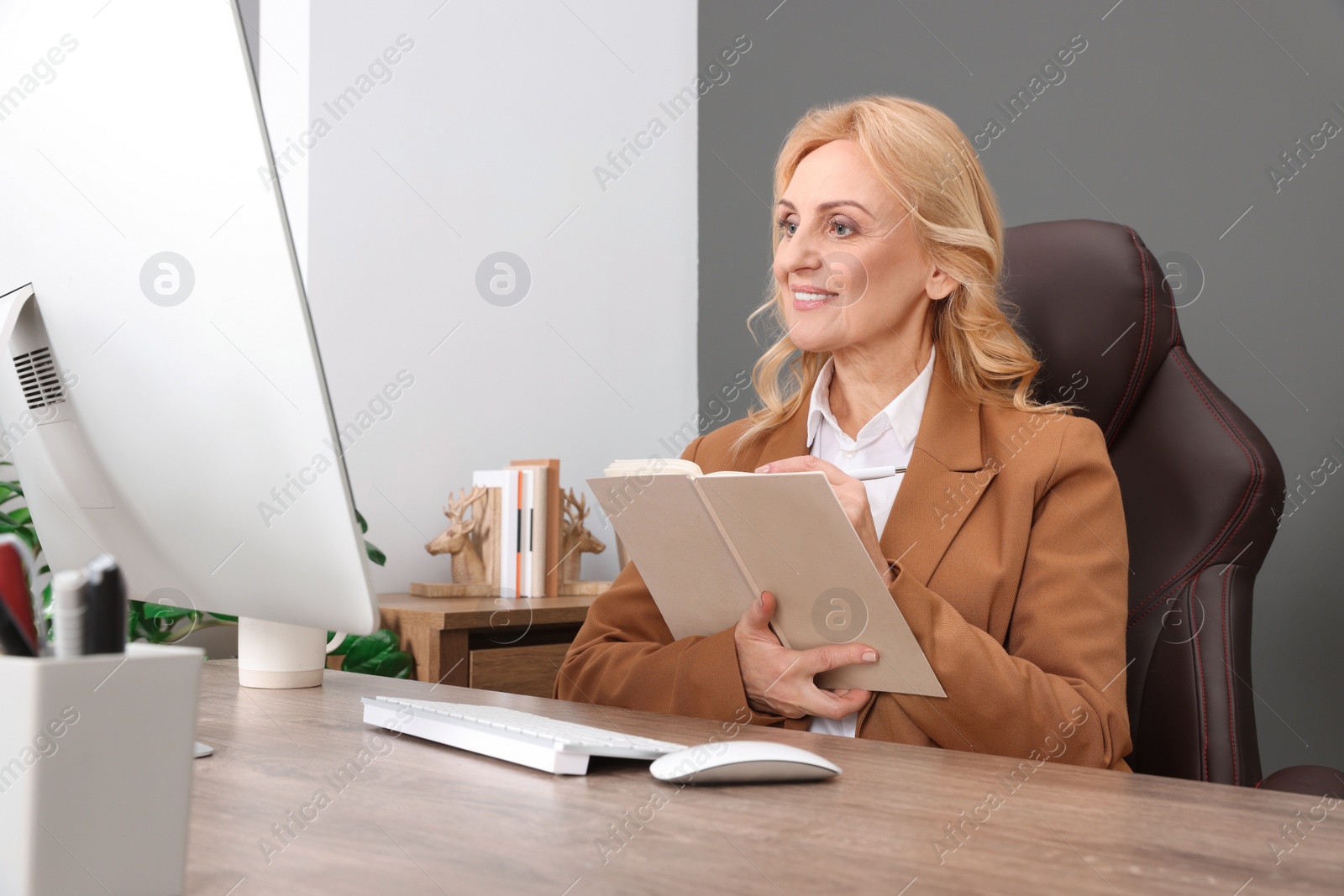 Photo of Lady boss working near computer at desk in office. Successful businesswoman