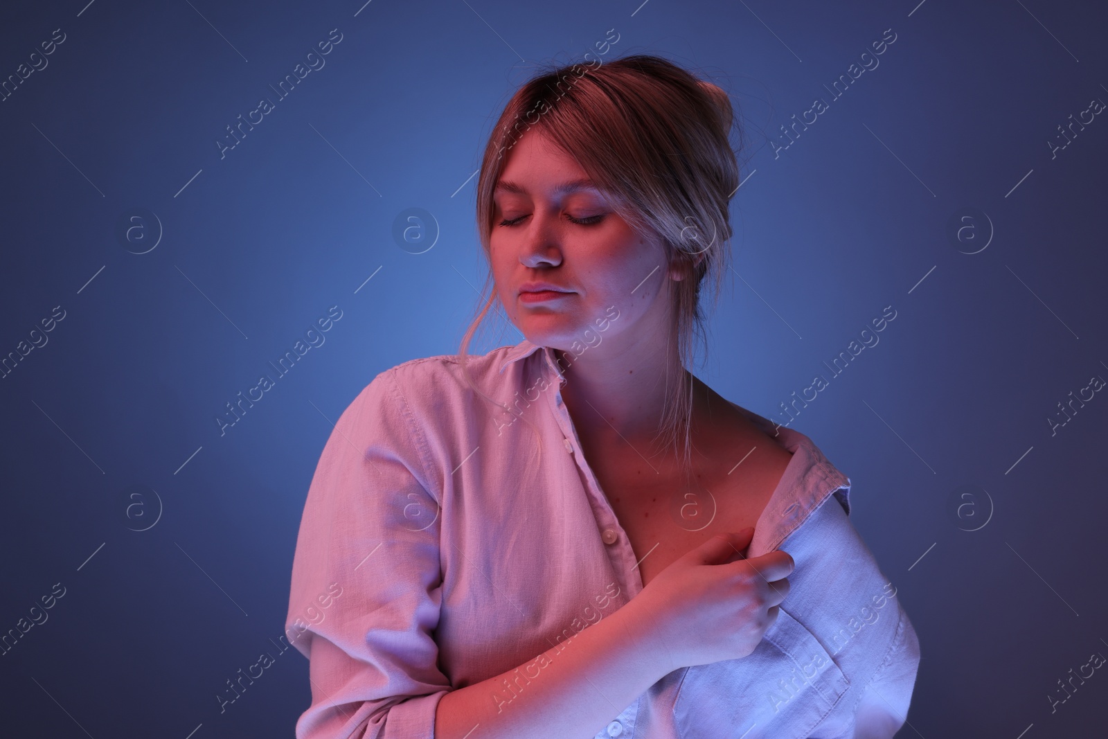 Photo of Portrait of beautiful young woman on color background with neon lights