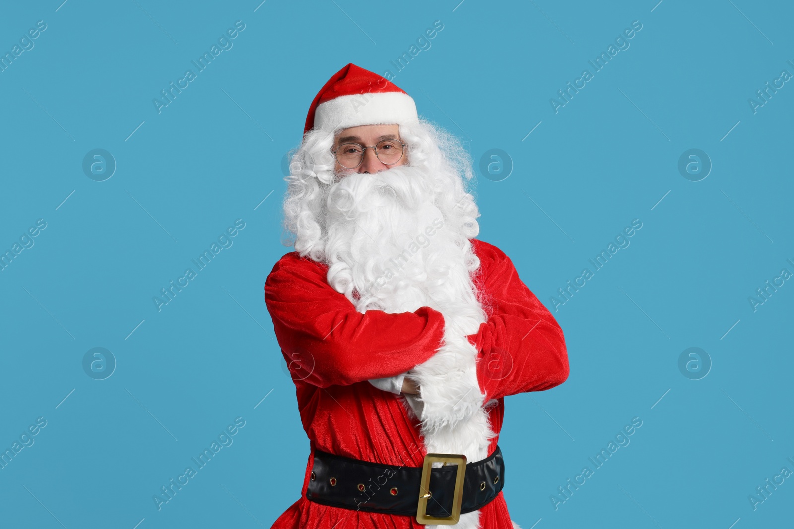 Photo of Merry Christmas. Santa Claus posing on light blue background