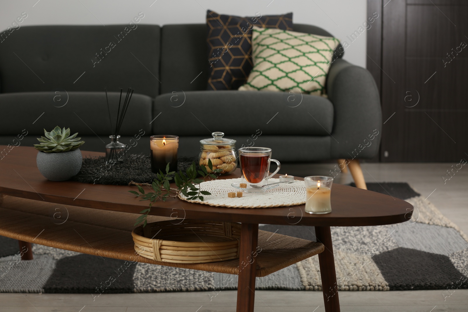 Photo of Tea, cookies and decorative elements on wooden table in living room